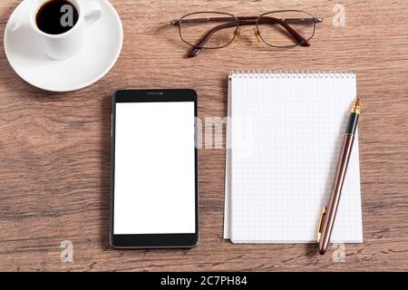 Ordinateur portable avec stylo, smartphone et café sur table en bois Banque D'Images