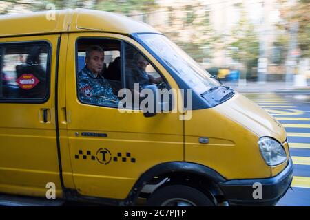 Un soldat est assis sur le siège avant d'un marshrutka ou minibus, la forme dominante des transports publics à Tbilissi, en République de Géorgie Banque D'Images