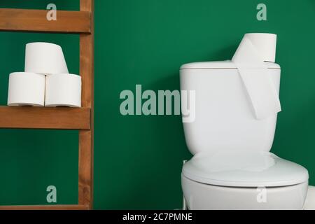 Cuvette de toilette avec papier près du mur de couleur dans les toilettes Banque D'Images