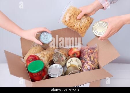 Les bénévoles mettent les produits dans la boîte de dons sur la table Banque D'Images