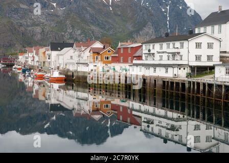 Vue sur le port avec des reflets d'eau des maisons et des bateaux à Henningsvaer, îles Lofoten, Norvège. Banque D'Images
