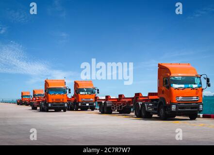 Flotte de camions et de remorques attendant de ramasser des conteneurs sur le port de la jetée. Transport et logistique des conteneurs, camionnage et livraison. Banque D'Images