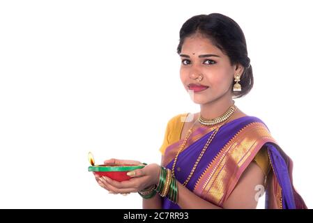 Portrait d'une femme tenant une photo de diya, Diwali ou deepavali avec des mains de femmes tenant une lampe à huile pendant le festival de lumière sur fond blanc Banque D'Images