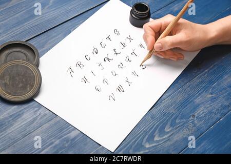 Femme pratiquant la calligraphie à la table Banque D'Images