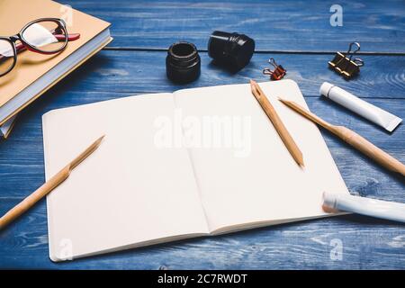 Composition avec bloc-notes, stylos à encre et encre sur table Banque D'Images