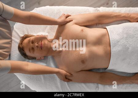 Beau homme recevant un massage dans le salon de spa Banque D'Images