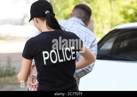 Un policier arrête un criminel à l'extérieur Banque D'Images