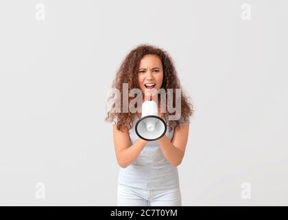 Proteste en colère contre une femme afro-américaine avec le mégaphone sur fond clair Banque D'Images