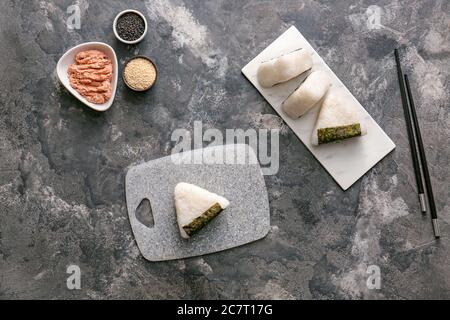 Onigiri japonais traditionnel avec des ingrédients sur fond gris Banque D'Images