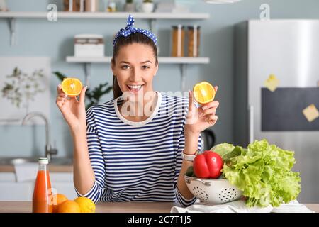 Belle jeune femme avec des produits frais dans la cuisine Banque D'Images