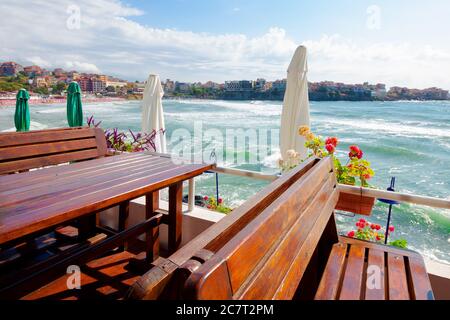 terrasse vide d'un restaurant sur la mer. belle vue sur la baie sous la lumière du matin. parasol décoratif au-dessus des tables et des sièges en bois. weat ensoleillé Banque D'Images