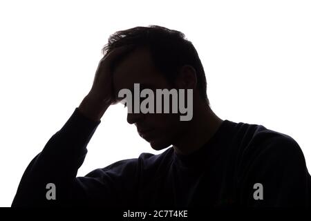 Un jeune homme avec le chagrin déchirant ses cheveux - silhouette Banque D'Images