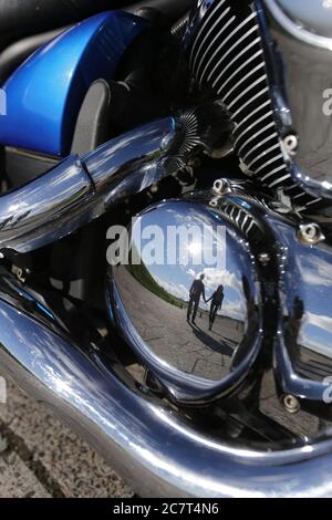 reflet du jeune couple dans le moteur de moto rétro Banque D'Images