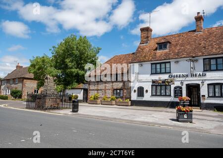 Le pub Queens Head, situé dans la rue haute de Ludgershal, une ville du Wiltshire, au Royaume-Uni, avec la croix de prédication médiévale Banque D'Images