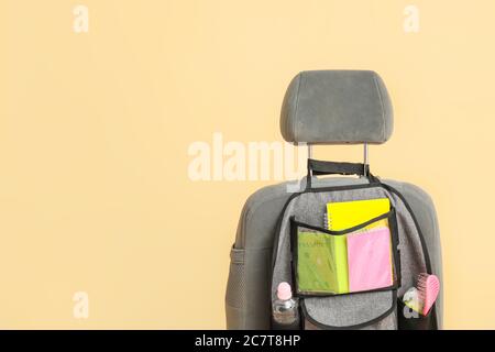 Organisateur de voyage avec différentes choses sur le siège d'auto sur fond de couleur Banque D'Images