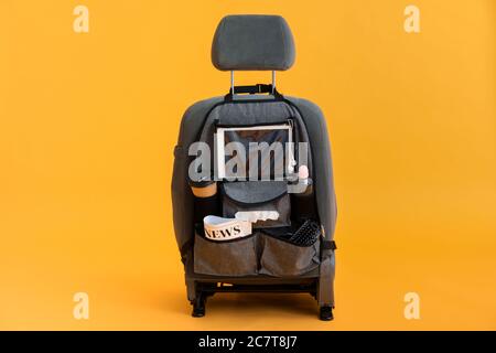 Organisateur de voyage avec différentes choses sur le siège d'auto sur fond de couleur Banque D'Images