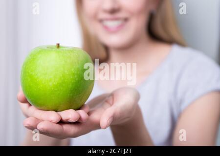 concept de nourriture saine - gros plan de la pomme verte dans la main de la femme Banque D'Images