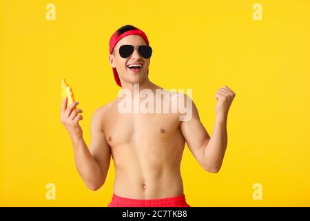 Jeune homme heureux avec crème de protection solaire sur fond de couleur Banque D'Images