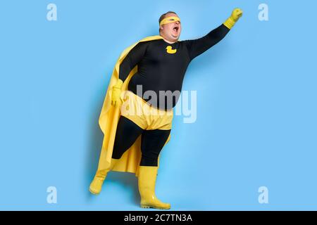 portrait du super-héros de nettoyage enthousiaste isolé sur fond bleu. canard jaune est un symbole de bain et de nettoyage. l'homme est prêt à nettoyer Banque D'Images