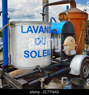 Appareil rétro pour la distillation de l'huile de lavande sur un marché rural en Provence, France. Titre sur le réservoir « Lavander du Soleil » signifie « Lavande du Soleil » Banque D'Images