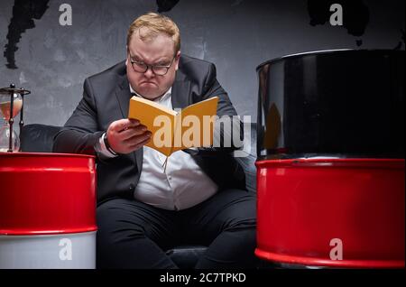 portrait d'un homme d'affaires en colère lisant un livre, l'homme n'a pas le temps de penser, il a besoin de résoudre des problèmes. concept de production de pétrole Banque D'Images