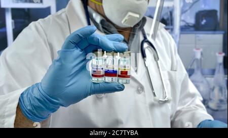 Trois flacons de vaccin de différents pays dans les mains d'un médecin. Chine vaccin, États-Unis, Russie. Banque D'Images