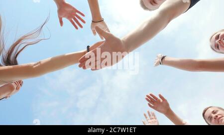 Amis amicaux clap les mains comme un signe d'amitié et de travail d'équipe. Banque D'Images
