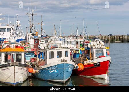 Le port de Scarborough. Les bateaux de pêche sont amarrés ensemble le long d'un quai. Leurs réflexions sont dans l'eau. Banque D'Images