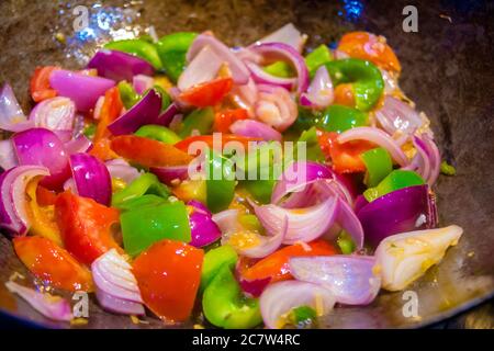 Remuez les légumes frits colorés dans un wok, aliments sains. Concept pour un repas végétarien savoureux et sain. Gros plan Banque D'Images