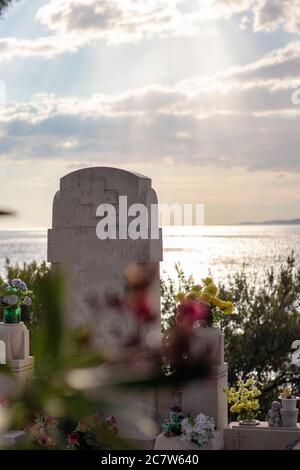 Ancien cimetière chrétien traditionnel et tombale, situé dans la ville de Primosten sur la côte adriatique. Journée d'été nuageux avec rayons de soleil Banque D'Images