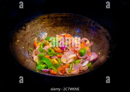 Remuez les légumes frits colorés dans un wok, aliments sains. Concept pour un repas végétarien savoureux et sain. Gros plan Banque D'Images