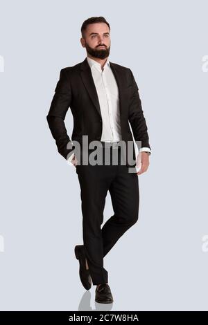 Portrait complet d'un élégant gentleman en costume d'affaires sur fond gris Banque D'Images