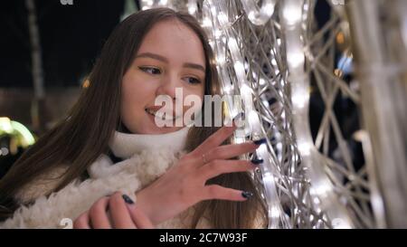 Bonne fille sur le fond de la guirlande de Noël. Banque D'Images