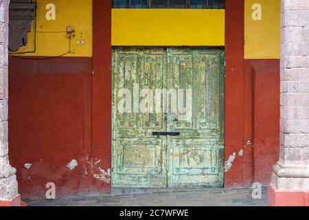 Une ancienne porte en bois peinte en vert sur la Plaza Allende à San Miguel de Allende, Guanajuato, Mexique. Banque D'Images