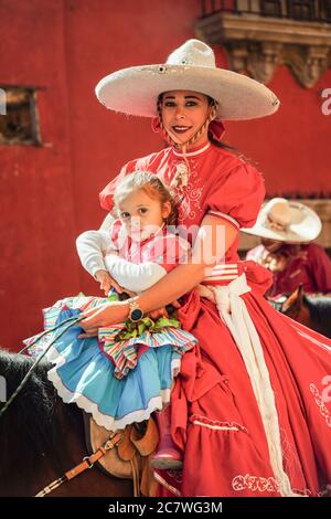 Une Cowgirl mexicaine et sa fille sont à cheval dans un défilé pour célébrer le 251e anniversaire du héros de l'indépendance mexicaine Ignacio Allende le 21 janvier 2020 à San Miguel de Allende, Guanajuato, Mexique. Allende, d'une famille riche à San Miguel a joué un rôle majeur dans la guerre d'indépendance contre l'Espagne en 1810 et plus tard honoré par sa ville natale en ajoutant son nom. Banque D'Images