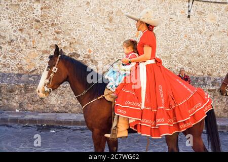 Une Cowgirl mexicaine et sa fille sont à cheval dans un défilé pour célébrer le 251e anniversaire du héros de l'indépendance mexicaine Ignacio Allende le 21 janvier 2020 à San Miguel de Allende, Guanajuato, Mexique. Allende, d'une famille riche à San Miguel a joué un rôle majeur dans la guerre d'indépendance contre l'Espagne en 1810 et plus tard honoré par sa ville natale en ajoutant son nom. Banque D'Images