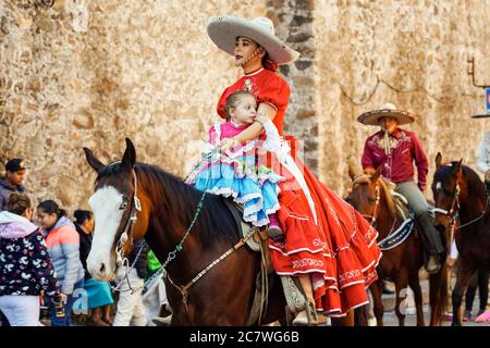 Une Cowgirl mexicaine et sa fille sont à cheval dans un défilé pour célébrer le 251e anniversaire du héros de l'indépendance mexicaine Ignacio Allende le 21 janvier 2020 à San Miguel de Allende, Guanajuato, Mexique. Allende, d'une famille riche à San Miguel a joué un rôle majeur dans la guerre d'indépendance contre l'Espagne en 1810 et plus tard honoré par sa ville natale en ajoutant son nom. Banque D'Images