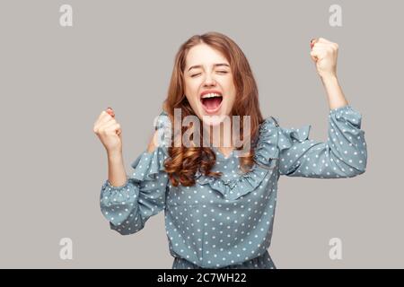 Je suis champion! Ravie heureuse fille enthousiaste ruffle chemisier levant les poings criant pour la joie excitation, célébrant la victoire de loterie, euphorie de victo Banque D'Images