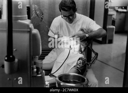 Philadelphie, Pennsylvanie. Circa.1960 - Un dentiste perçant la dent d'une patiente. Banque D'Images