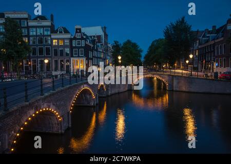 Les lumières de la ville se réfléchit sur le canal de l'eau la nuit, Amsterdam, pays-Bas Banque D'Images