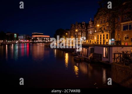 Réflexion sur le canal de la ville illuminée d'Amsterdam la nuit, pays-Bas. Banque D'Images