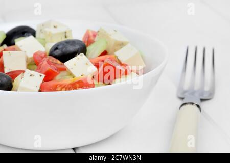 Salade de légumes dans un bol sur une table en bois blanc Banque D'Images
