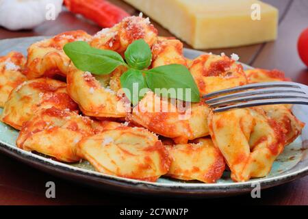 Tortellini avec sauce tomate dans une assiette sur la table Banque D'Images