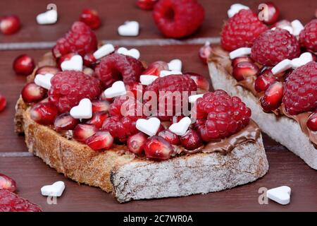 Deux tranches de pain au chocolat et à la framboise sur une table en bois brun Banque D'Images