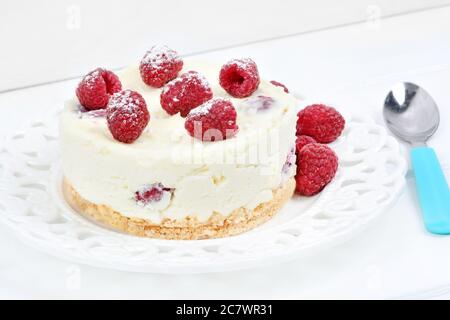 Mini cheesecake au chocolat blanc et aux framboises sur fond de bois blanc Banque D'Images