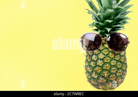 Ananas frais avec lunettes de soleil sur fond jaune Banque D'Images