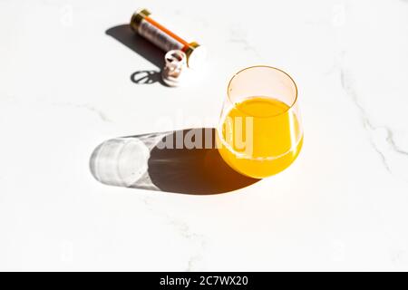 Gros plan d'un comprimé immunostimulant à effet de multivitamines effervescent et d'un verre de jus Banque D'Images