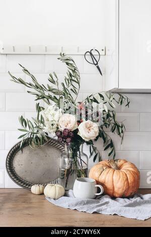 Composition de la vie fixe d'automne. Tasse de café, plateau argenté vintage et bouquet floral. La cuisine d'automne encore la vie avec des citrouilles. Arrière-plan de la table en bois Banque D'Images