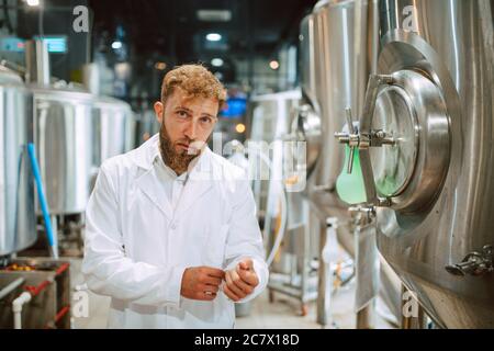 Portrait d'un technologue caucasien professionnel expert en uniforme blanc debout dans une usine pharmaceutique ou alimentaire - usine de production Banque D'Images