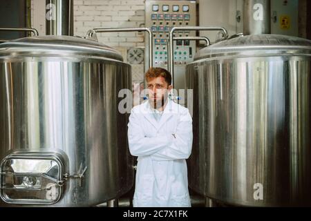 Portrait d'un technologue caucasien professionnel expert en uniforme blanc debout dans une usine pharmaceutique ou alimentaire - usine de production Banque D'Images